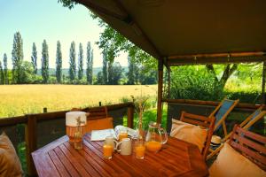 - une table en bois avec des verres de jus d'orange dans l'établissement Camping Moulin de Paulhiac, à Daglan