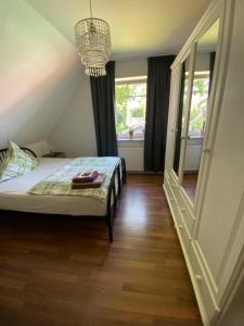 1 dormitorio con cama y lámpara de araña en Ferienwohnung Halen Landkreis Cloppenburg, 