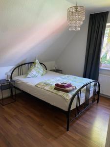 a bed in a bedroom with a chandelier at Ferienwohnung Halen Landkreis Cloppenburg 
