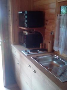 a small kitchen with a stove and a sink at Les Insolites de Nini in Grainville-Ymauville