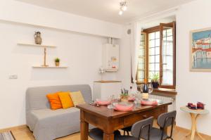 una sala de estar con una mesa y un sofá en Aosta Centro Storico - Les Cretes Apartment Netflix & Relax, en Aosta 16 fotos más