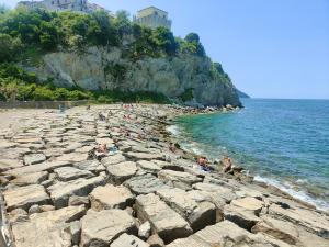 アグローポリにあるAppartamenti Sole Mare Agropoliの海岸の岩に座る人々