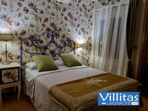 a bedroom with a bed with floral wallpaper at VILLAZUL by Villitas in Playa Blanca