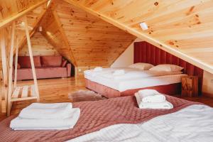 a room with two beds in a wooden attic at OSADA LEŚNA - domki z basenem in Stare Miasto +53 photos