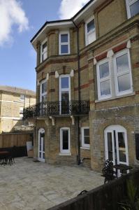 a large brick house with a balcony on a patio at The Victorian lodge in Ryde