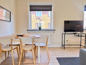 a dining room with a table and chairs and a tv at Three Bedroom Apartment In Valby, Valby Langgade 214, in Copenhagen