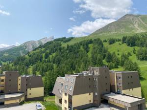 un groupe de bâtiments devant une montagne dans l'établissement Appartement 2 chambres - La Foux d'Allos, les Balcons du soleil - Vue magnifique, à Allos