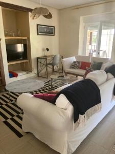 a living room with white couches and a tv at El encanto de un pueblo 