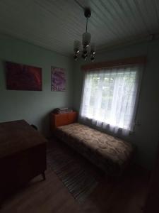 um quarto com uma cama em frente a uma janela em Vila Puriena em Kurtuvėnai
