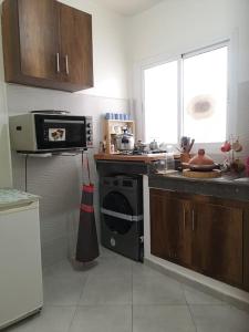 a kitchen with a stove and a sink and a microwave at Your Sweet Appartment in Fez