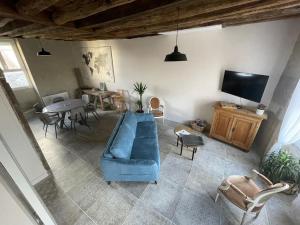 a living room with a blue couch and a tv at À côté de la Loire in Blois
