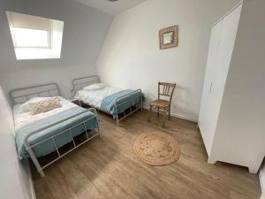 2 camas en una habitación con silla y alfombra en Côté Loire, en Blois