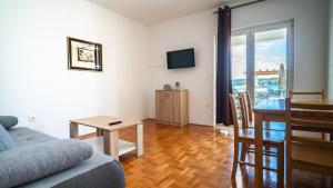 ein Wohnzimmer mit einem Sofa und einem Tisch in der Unterkunft Calma apartments in Trogir