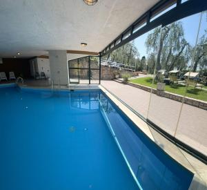 a large swimming pool with blue water in a building at Lola Home Brenzone in Brenzone sul Garda