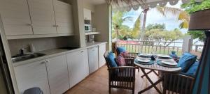 una cucina con tavolo e sedie e un balcone di Studio Sable 2/4 pers face à la mer a Sainte-Anne Altre 27 foto