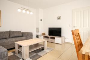 a living room with a couch and a table at Sanddornweg Wohnung 13 a in Boltenhagen