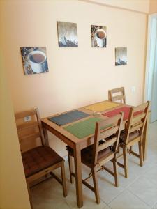 a dining room with a wooden table and chairs at D apartment in Nea Kallikrateia