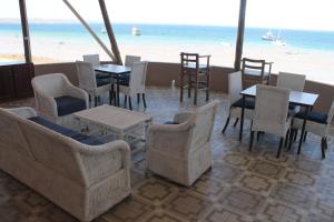 een restaurant met tafels en stoelen en het strand bij Wharf Side Inn in Pemba