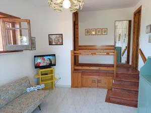 un soggiorno con divano e TV di La Residenza estiva della Marchesina by Holiday World a Ognina