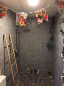 ein Bad mit einer Dusche mit Blumen an der Wand in der Unterkunft Les Sainfoins, Idéal voyageurs Pro in Villeneuve-sur-Yonne