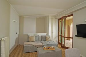 uma sala de estar com uma cama, um sofá e uma televisão em Casa Monte Cicogna PT-1 by Wonderful Italy em Moniga