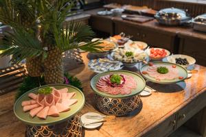 a table with plates of food on top of it at La Passion Hanoi Hotel & Apartment in Hanoi +19 photos