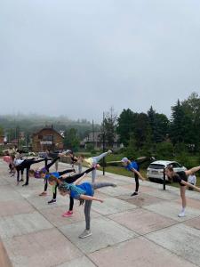 eine Gruppe von Leuten, die auf einem Parkplatz Yoga machen in der Unterkunft Tourkomplex Karpaty in Slawske