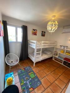 La Garonnette-PlageにあるVilla Romanaの二段ベッド2台とラグが備わる客室です。