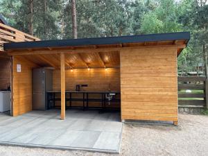 een houten paviljoen met een keuken op een patio bij Camping nad Warta 