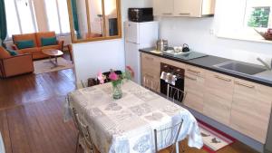 a kitchen with a table with a vase of flowers on it at Les rosieres 2 