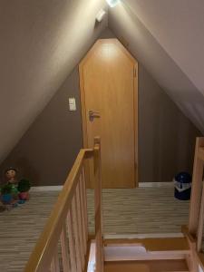 a staircase with a wooden door in a attic at Ferienwohnung Halen Landkreis Cloppenburg 