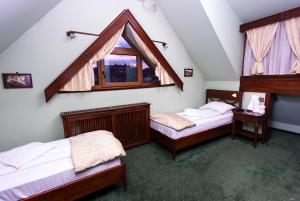 a bedroom with three beds and a window at Pension Brasovu Vechi in Braşov
