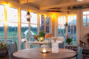 a porch with a wooden table and some windows at FARM LIVING in Gottby