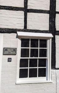 una ventana en el lateral de un edificio de ladrillo en Cosy character cottage in central Marlborough UK, en Marlborough