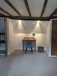Cosy character cottage in central Marlborough UK في مارلبوره: غرفة مع مكتب خشبي مع كرسي أزرق