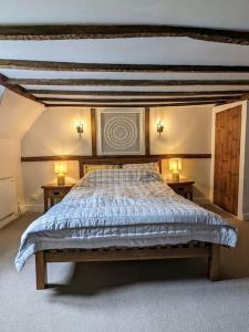Cosy character cottage in central Marlborough UK في مارلبوره: غرفة نوم بسرير كبير مع مواقف ليلتين