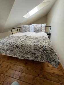 a bedroom with a bed with a black and white comforter at CE Apartment Prague Castle in Prague
