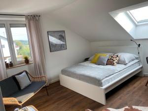 1 dormitorio con 1 cama, 1 silla y ventanas en Ferienwohnung 3SZ, großer Balkon , naturnah 