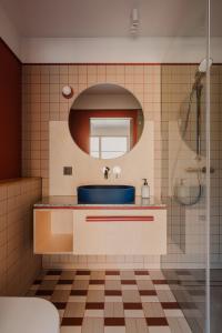 ein Badezimmer mit einem blauen Waschbecken und einem Spiegel in der Unterkunft Płyniewoda - całoroczne domy PREMIUM, klimatyzacja, kominek, blisko morza in Dziwnów