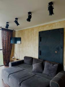 een woonkamer met een grote zwarte bank en verlichting bij Apartment panorama center Varna in Varna
