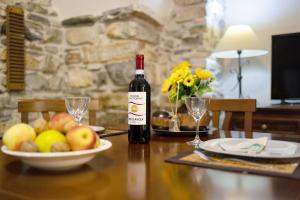- une bouteille de vin assise sur une table avec un bol de fruits dans l'établissement Ca dei nonni, à Diano San Pietro