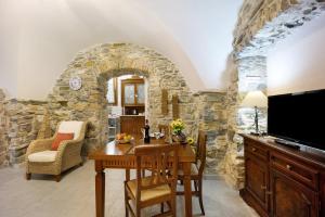 - une cuisine avec une table et un mur en pierre dans l'établissement Ca dei nonni, à Diano San Pietro