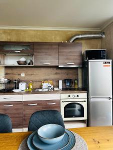 een keuken met houten kasten en een witte koelkast bij Apartment panorama center Varna in Varna