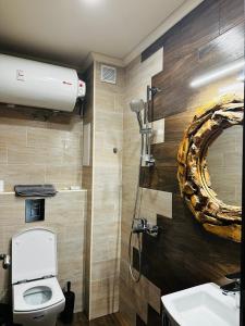 een badkamer met een toilet, een wastafel en een spiegel bij Apartment panorama center Varna in Varna