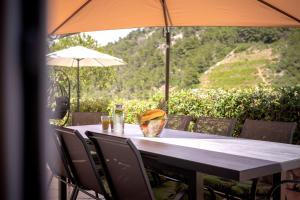 a long table with chairs and an umbrella at Stiniva Bay - Hvar Villa in Brusje