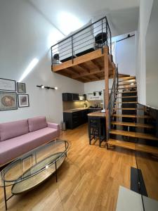 ein Wohnzimmer mit einem Sofa und einer Wendeltreppe in der Unterkunft CE Apartment Prague Castle in Prag