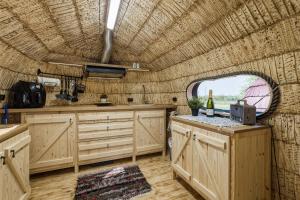 a kitchen with wooden cabinets and a large window at Saare Paadiküla in Veskiküla +68 photos