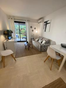 uma sala de estar com um sofá e uma mesa em T2 avec Terrasse et Jardin em Cannes