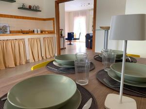 einen Tisch mit grünen Tellern und Gläsern darüber in der Unterkunft Dimarù in Gragnano