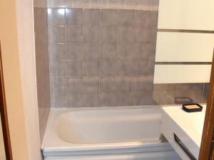 ein Bad mit einer weißen Badewanne in einem Zimmer in der Unterkunft Studio Saint-Jean-d'Aulps, 1 pièce, 4 personnes - FR-1-573-116 in Saint-Jean-dʼAulps